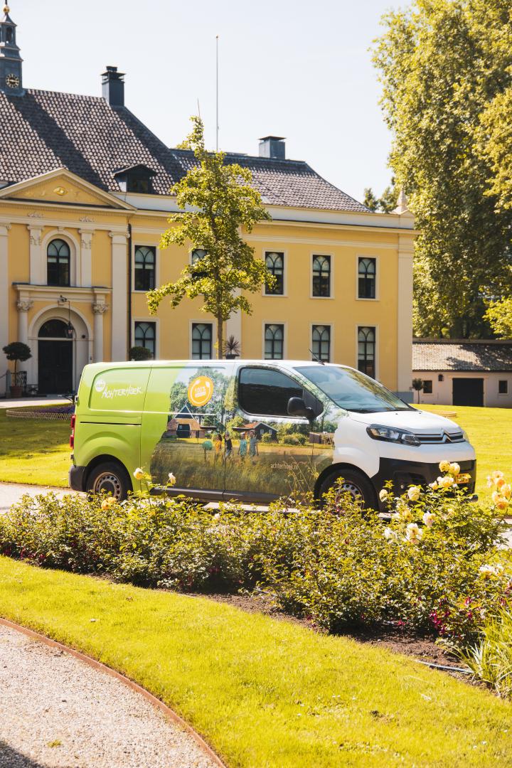 Foto van de bus van Achterhoek Toerisme geparkeerd voor het historisch Landgoed Huis Landfort.