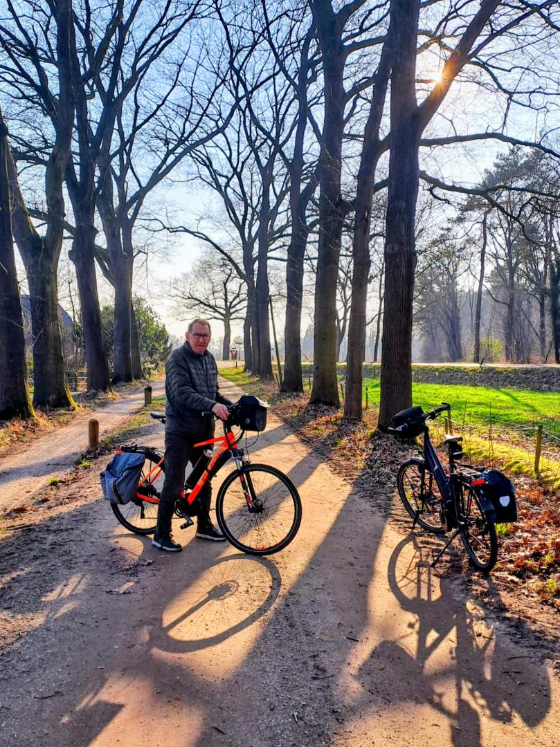Fietser staat op het fietspad met zijn fiets, terwijl hij de route Ode aan het Landschap volgt.